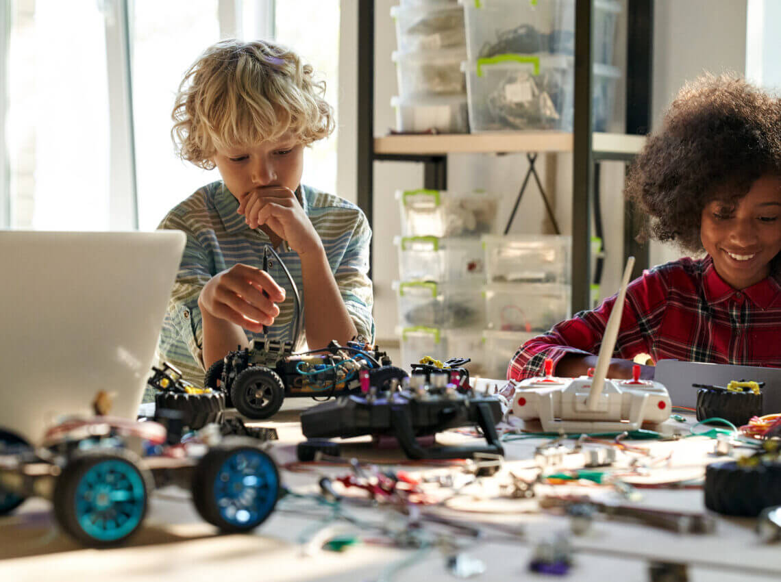 Group of diverse schoolkids on STEM science engineering educational class.