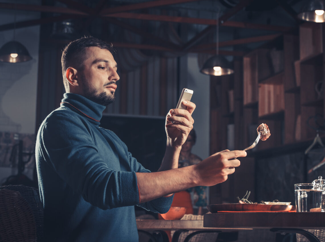 man photographing food